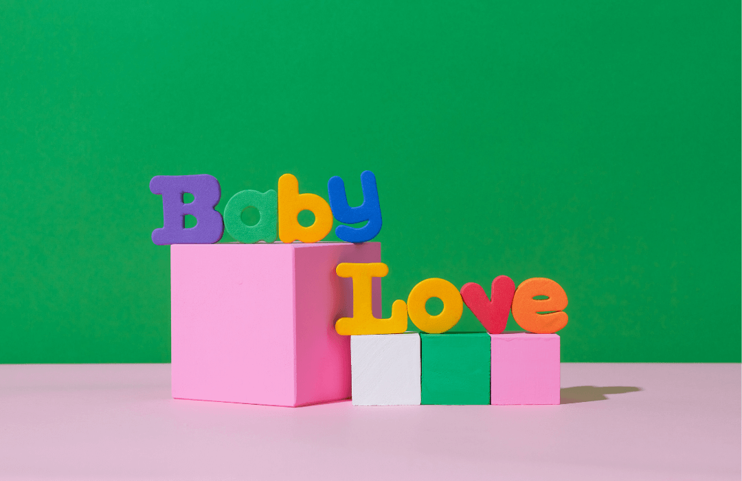 baby love foam letters on blocks on green and pink background