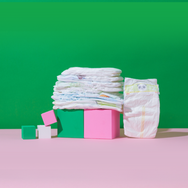 diapers stacked on green and pink blocks, green background